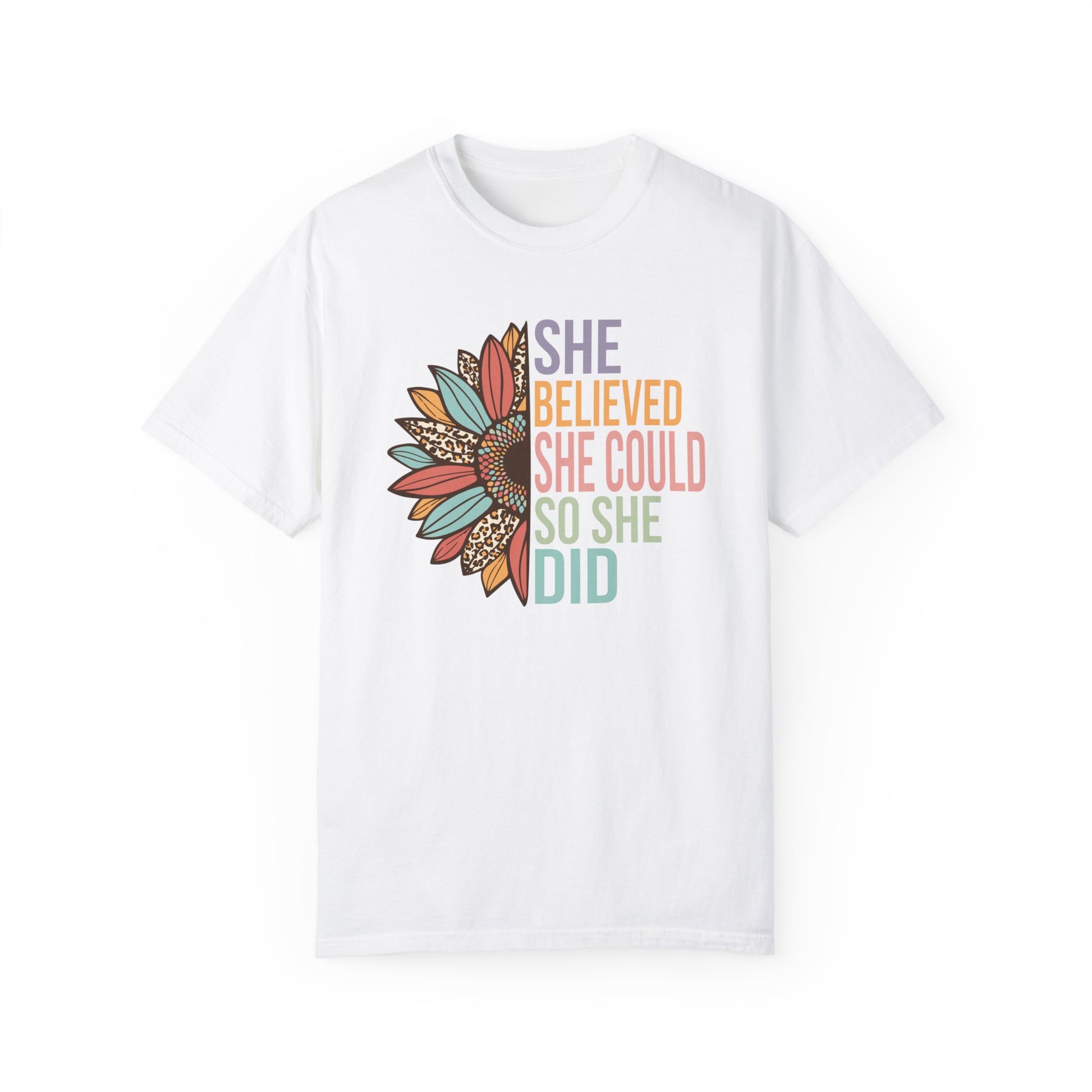 White colored t-shirt with the saying "She Believed She Could So She Did" as half of the sunflower and a retro design other half of the flower with petals of leopard print, teal, rust and golden yellow