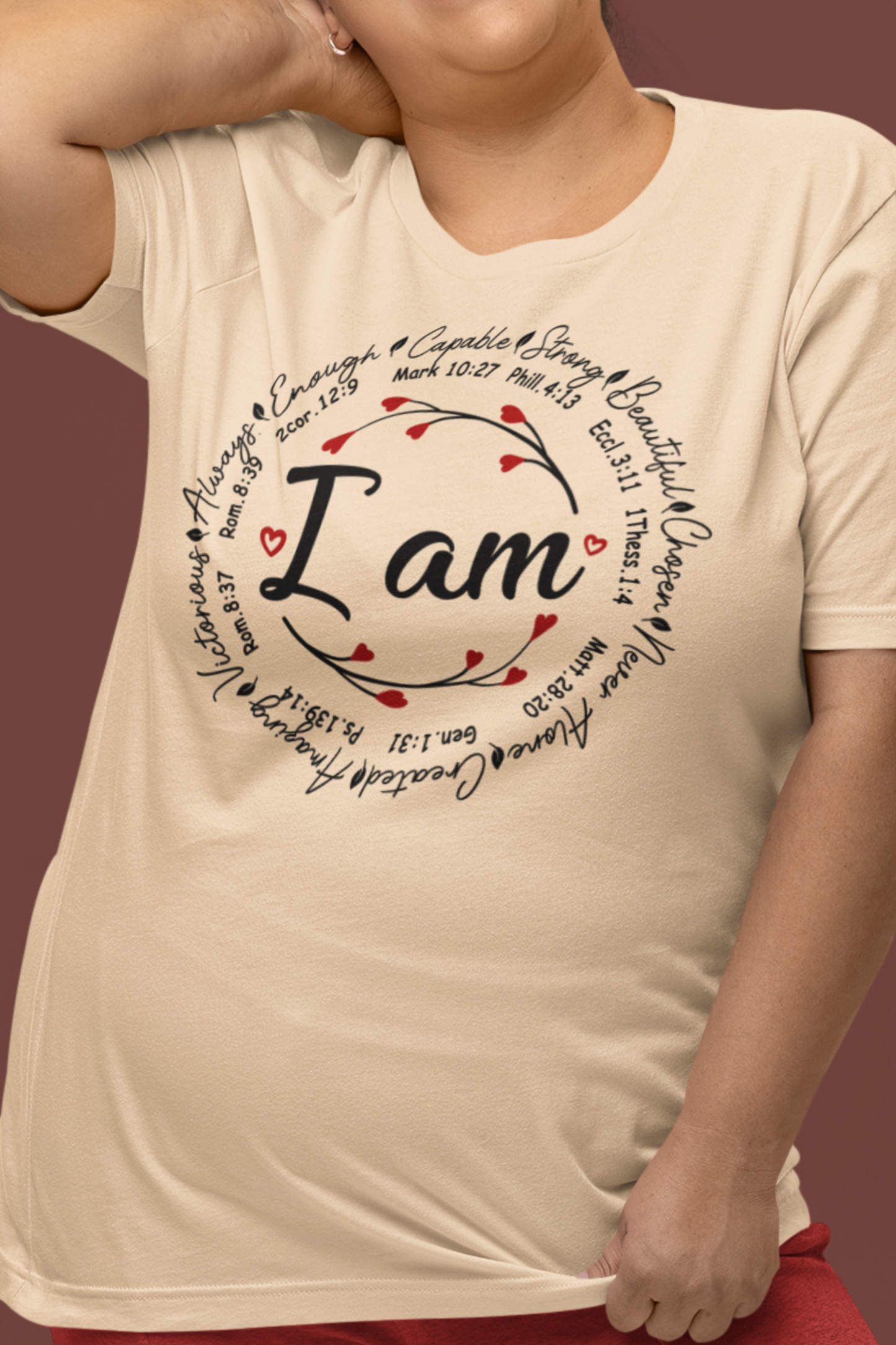 Ivory color graphic t-shirt with "I Am" in the middle"  Surrounded by branches with hearts as the buds then further surrounded on the outside of the circle the words "Capable, strong, beautiful, chosen, Never Alone, Created, Amazing, Victorious, Always, Enough" with corresponding bible verse references under each word.  Graphic is on the front and the back is plain, no graphic.  Modeled by a woman.