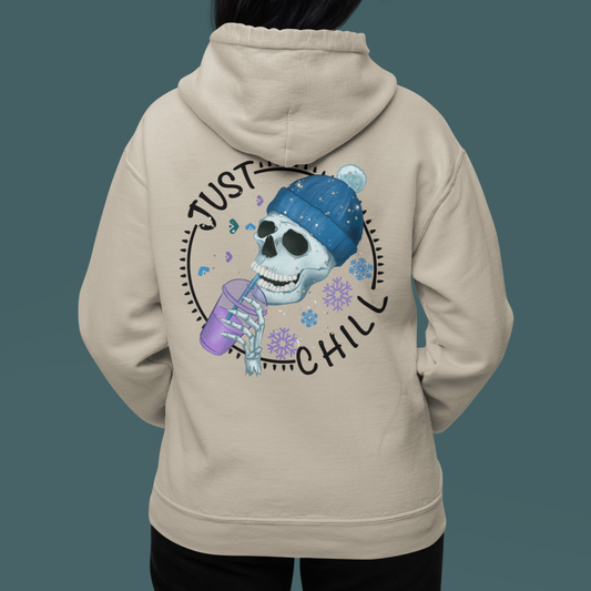 Sand colored hoodie with graphic on front and back. Front has snow flake on left pocket chest pocket area.  Back has a cute skeleton with winter hat drinking an iced coffee surrounded by the words just chill in a circle with decorative elements filling the gap between the words in a circle.  Circle also has snowflakes filling in the open space around the skeleton. Woman modeling back of sweatshirt