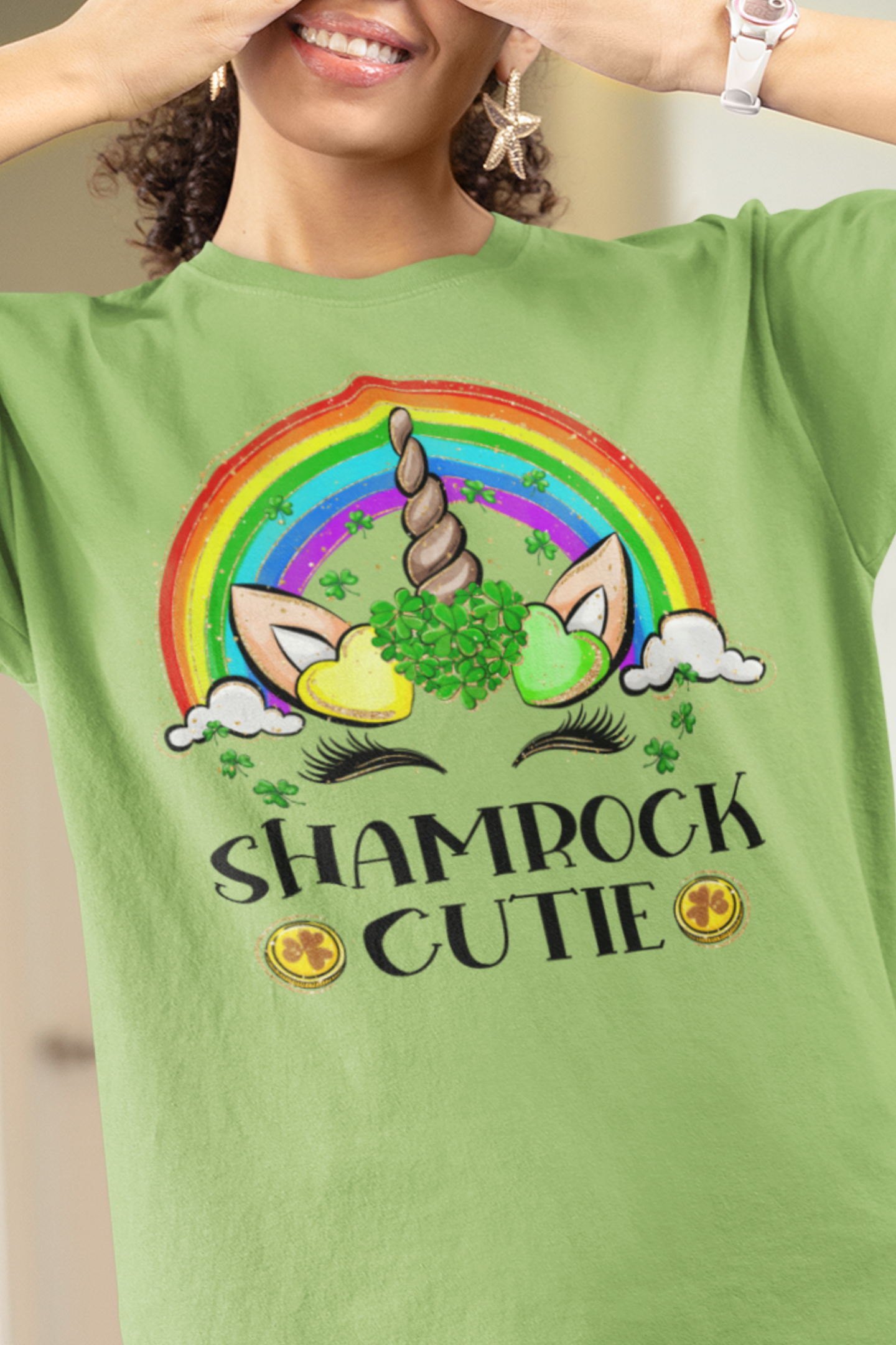 Lime color St. Patrick's Day T-Shirt with a rainbow surrounding a unicorn with hearts at the base of the horn one made up of shamrocks and the words Shamrock Cutie under the unicorn face. Woman Mock up