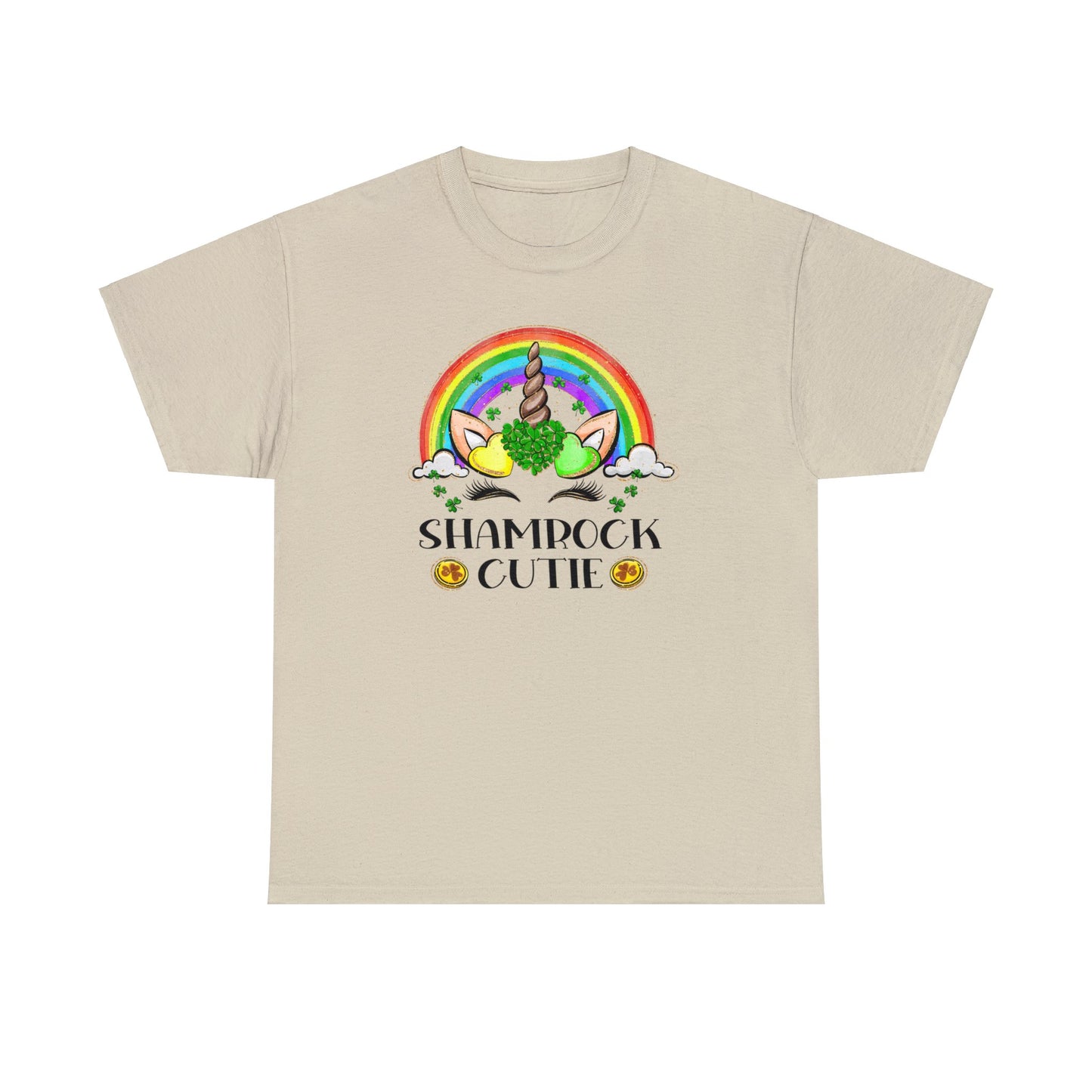 Sand color St. Patrick's Day T-Shirt with a rainbow surrounding a unicorn with hearts at the base of the horn one made up of shamrocks and the words Shamrock Cutie under the unicorn face.