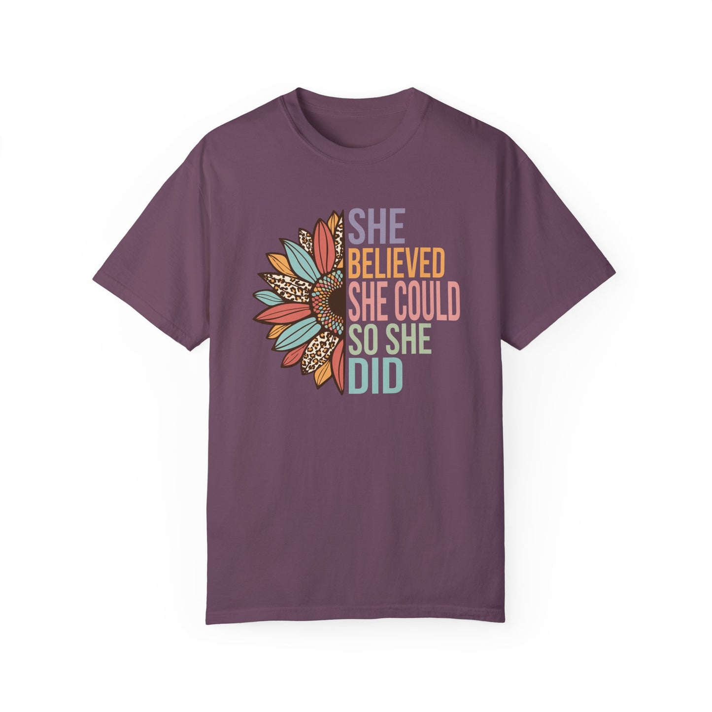 Berry colored t-shirt with the saying "She Believed She Could So She Did" as half of the sunflower and a retro design other half of the flower with petals of leopard print, teal, rust and golden yellow