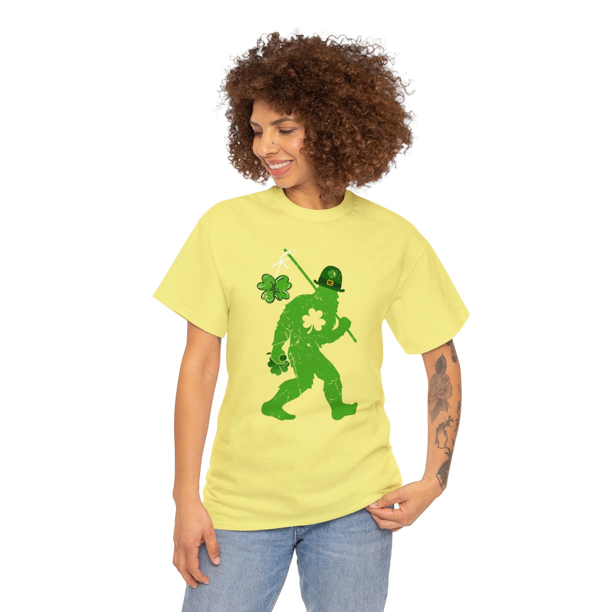 Cornsilk color St. Patrick's Day T-shirt with bigfoot wearing a leprechaun hat carrying a fishing pole with a shamrock attached to it. Woman mockup