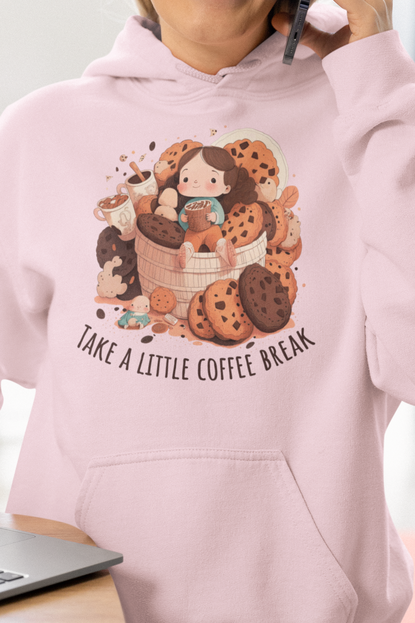 Light Pink colored hooded shirt with front graphic.  Cute girl sitting on a basket of cookies holding coffee with two other coffees on one side.  Underneath in an upward curve says "Take a Little Coffee Break".  Back of sweatshirt is plain - no graphic. Modeled by woman